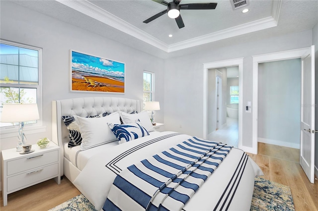 bedroom with light hardwood / wood-style flooring, a raised ceiling, ceiling fan, and crown molding