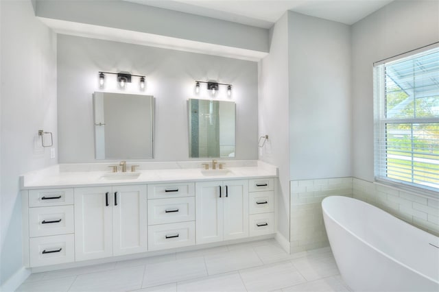 bathroom with plenty of natural light, vanity, a bath, and tile walls