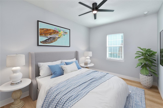 bedroom with ceiling fan and light hardwood / wood-style flooring