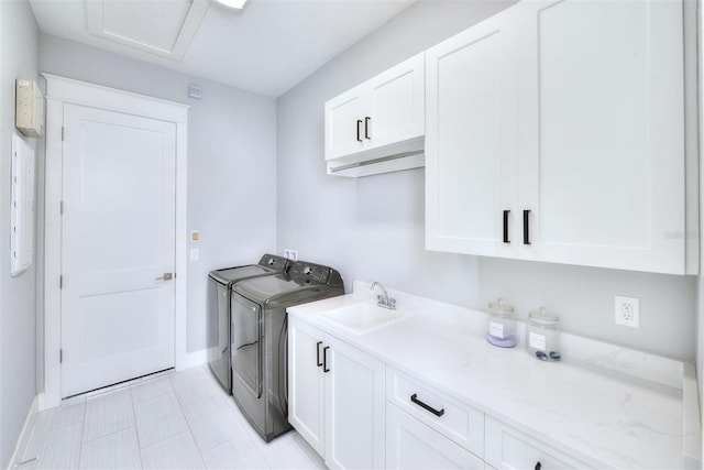 laundry room featuring cabinets, sink, and washing machine and clothes dryer