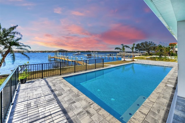 pool at dusk featuring a water view and a dock