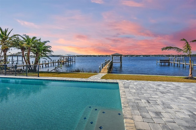 pool at dusk with a dock and a water view