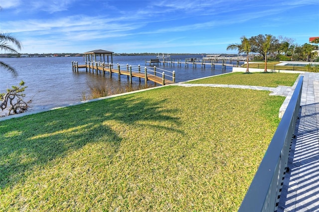 dock area featuring a lawn and a water view