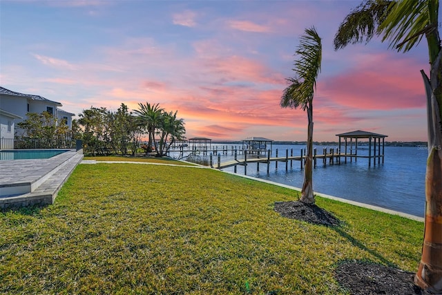 view of dock featuring a water view and a lawn