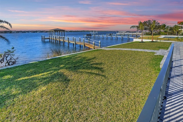 dock area featuring a yard and a water view