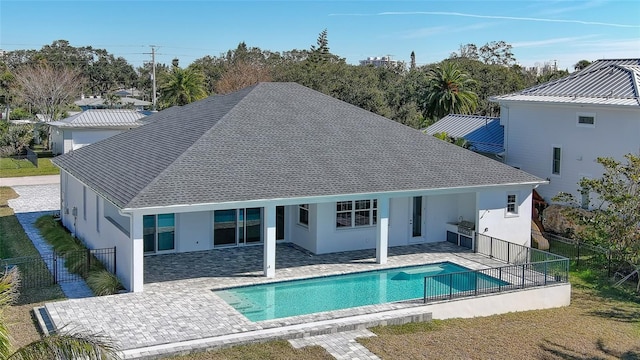 rear view of property featuring a fenced in pool and a patio area