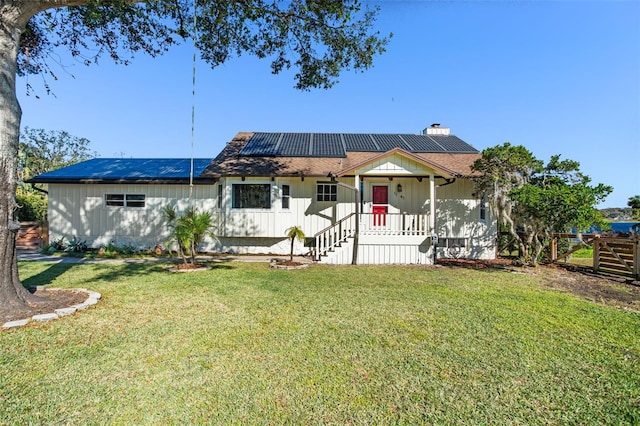 view of front of property with solar panels and a front lawn