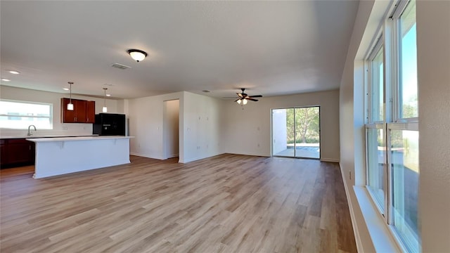 kitchen featuring a wealth of natural light, black refrigerator, ceiling fan, and sink