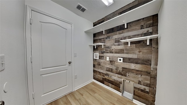 doorway with wood walls and light hardwood / wood-style flooring