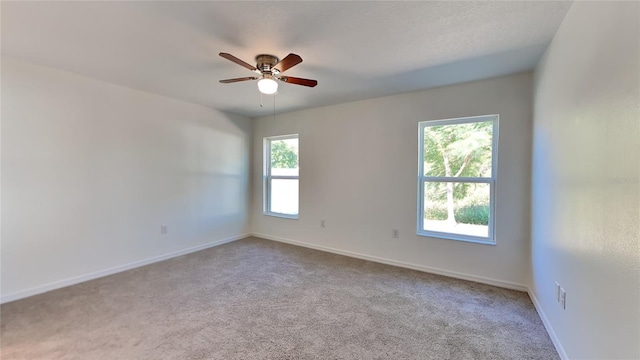 unfurnished room with ceiling fan and light carpet