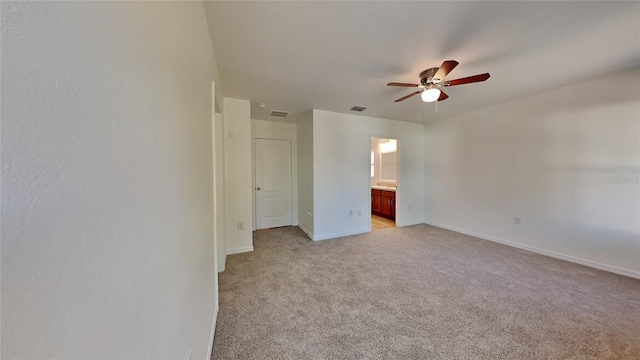 unfurnished bedroom with ensuite bathroom, ceiling fan, and light carpet