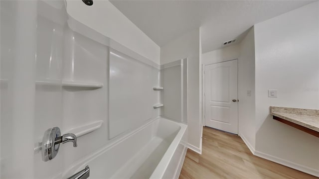 bathroom with vanity,  shower combination, and hardwood / wood-style flooring