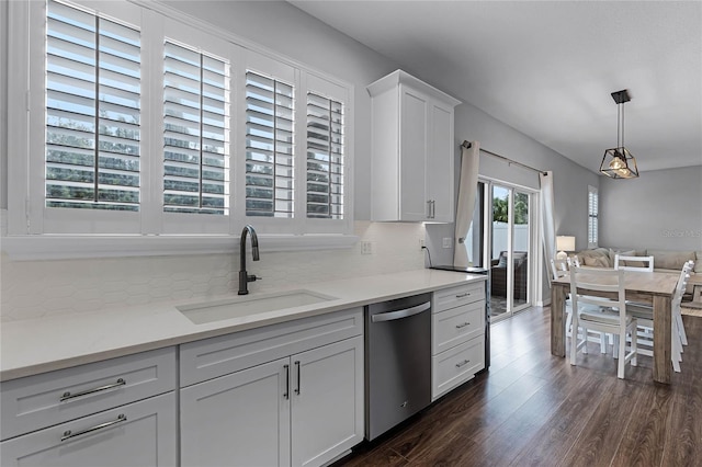 kitchen with light stone countertops, tasteful backsplash, stainless steel dishwasher, sink, and white cabinets