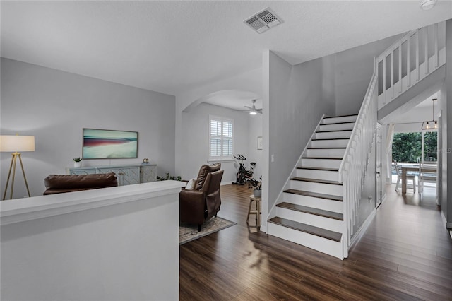 living room with ceiling fan and dark wood-type flooring