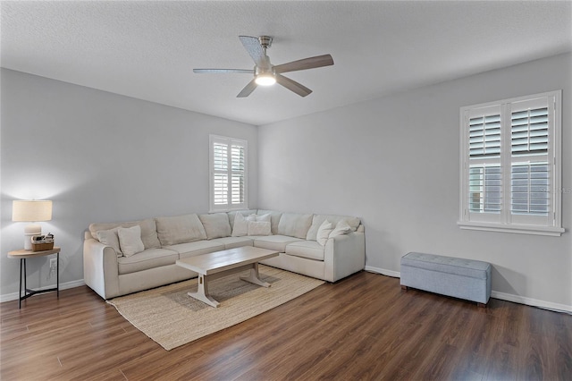 living room with ceiling fan, dark hardwood / wood-style flooring, and a textured ceiling