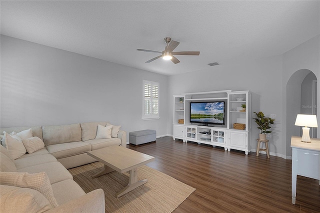 living room featuring a textured ceiling, ceiling fan, and dark hardwood / wood-style floors