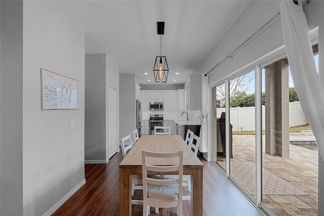 dining area featuring dark wood-type flooring and sink