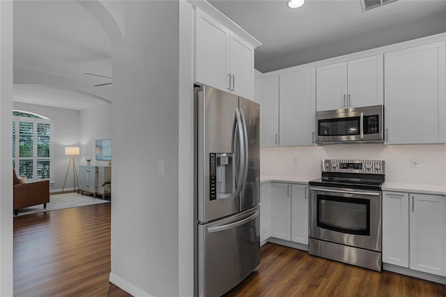 kitchen featuring white cabinets, appliances with stainless steel finishes, backsplash, and dark hardwood / wood-style floors