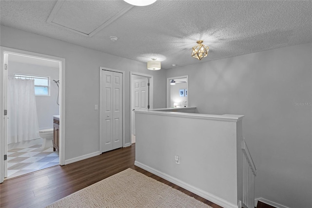 unfurnished room featuring a textured ceiling, ceiling fan, and dark hardwood / wood-style floors