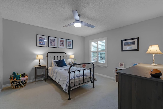 bedroom with a textured ceiling, carpet floors, and ceiling fan