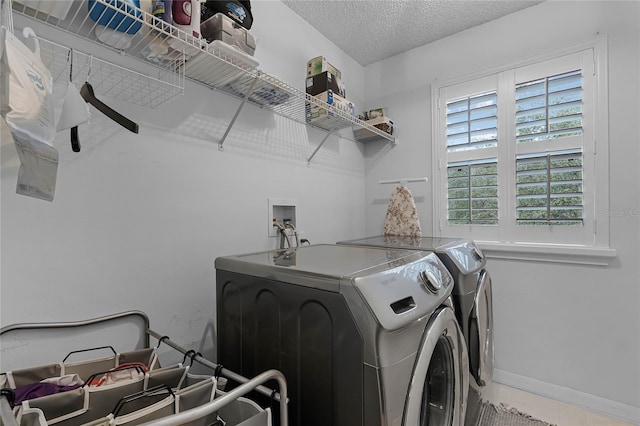 laundry room with washer and dryer, a textured ceiling, and tile patterned flooring