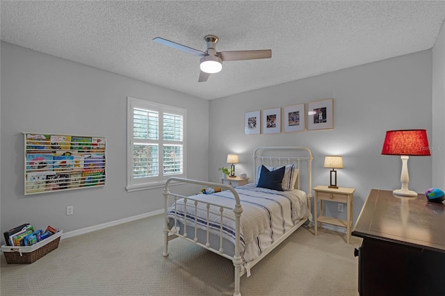 bedroom featuring a textured ceiling, ceiling fan, and light carpet