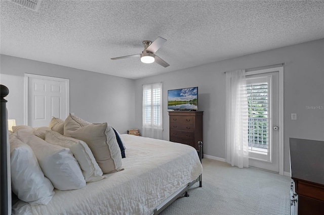 carpeted bedroom with multiple windows, a textured ceiling, and ceiling fan