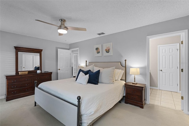 bedroom with light carpet, a textured ceiling, and ceiling fan