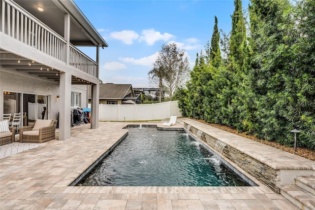 view of swimming pool with an outdoor living space, pool water feature, and a patio