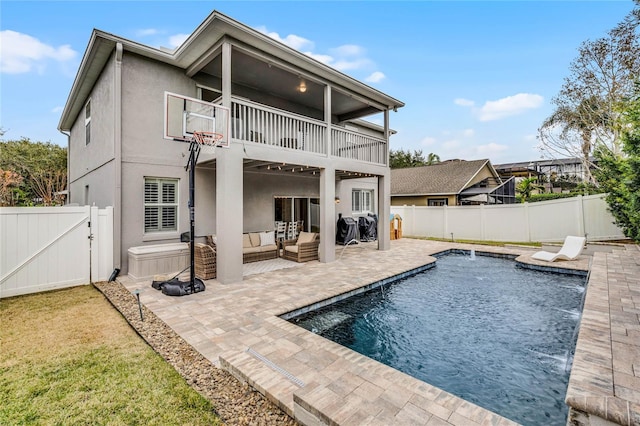 back of property with outdoor lounge area, pool water feature, a balcony, a fenced in pool, and a patio