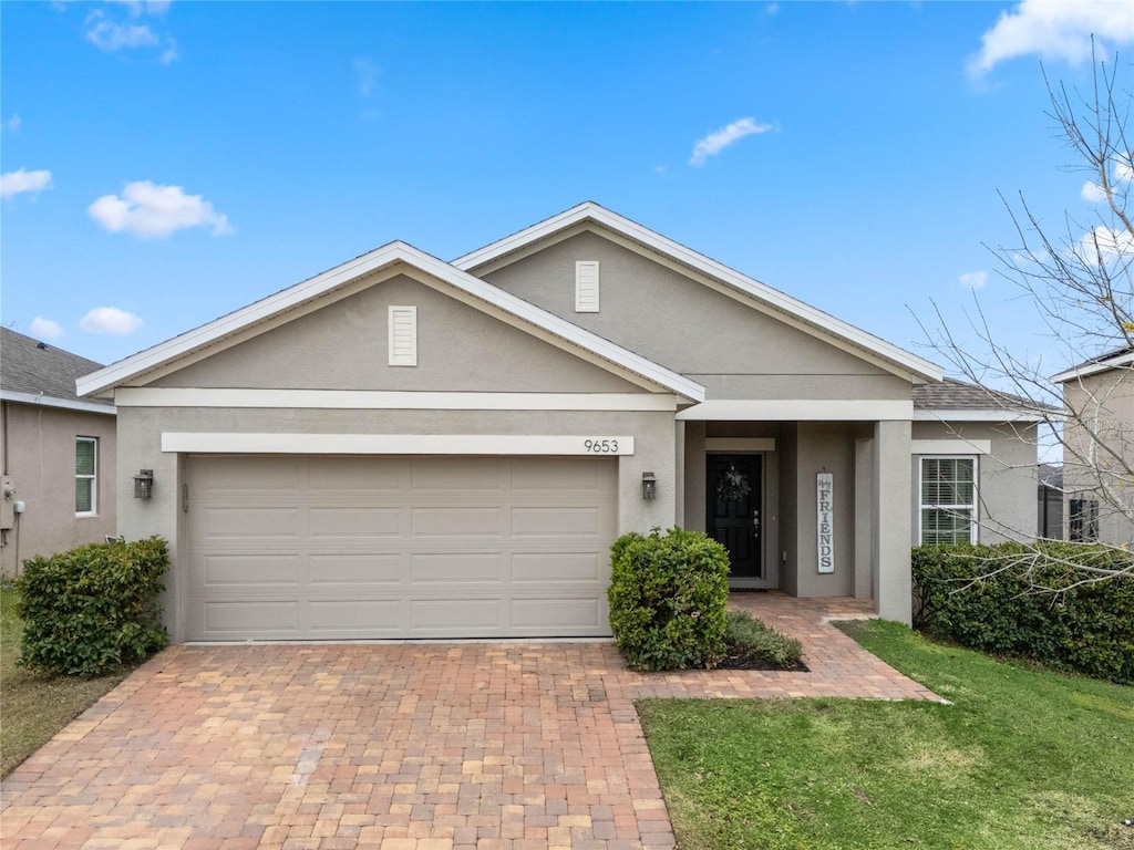 ranch-style house with a garage and a front lawn