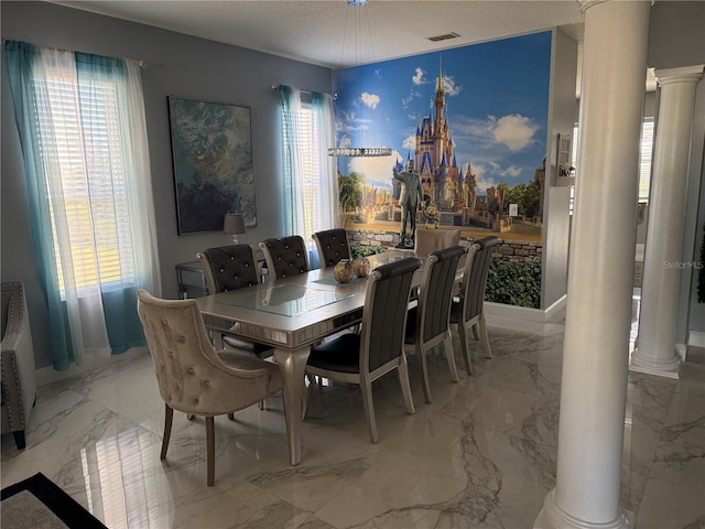 dining room with a textured ceiling and decorative columns