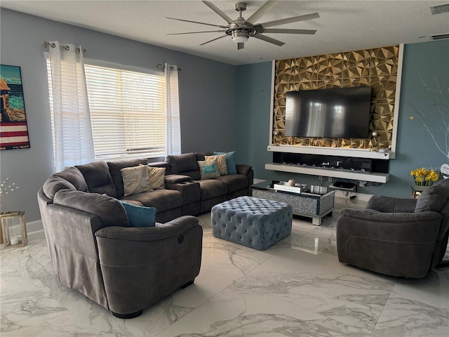 living room featuring ceiling fan and a textured ceiling