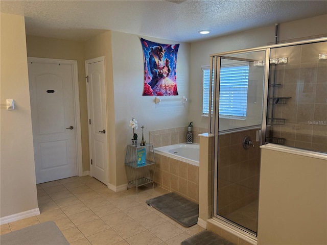 bathroom featuring separate shower and tub, tile patterned flooring, and a textured ceiling