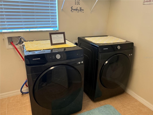 washroom with light tile patterned flooring and washing machine and clothes dryer