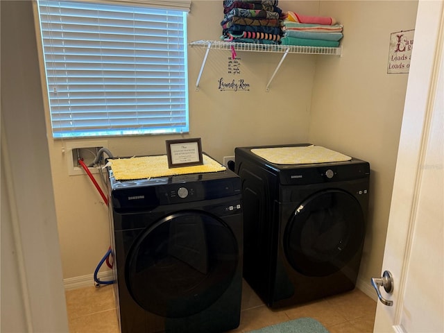 clothes washing area featuring washer and dryer and light tile patterned floors