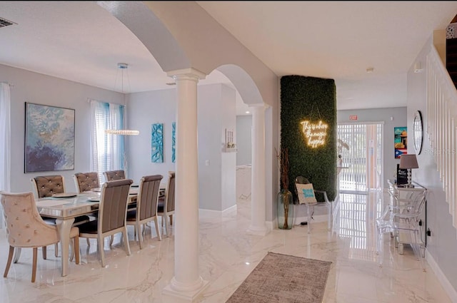 dining area with a healthy amount of sunlight and decorative columns