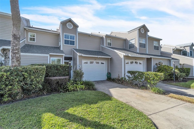 townhome / multi-family property featuring a garage and a front lawn