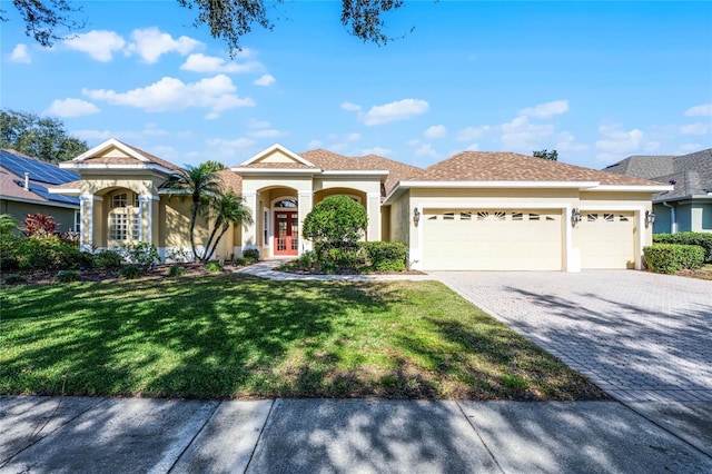 view of front of home with a front yard and a garage