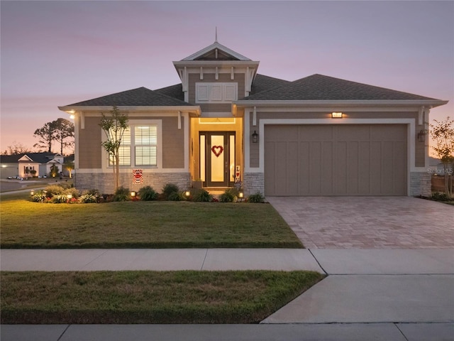 view of front of property with a garage and a lawn