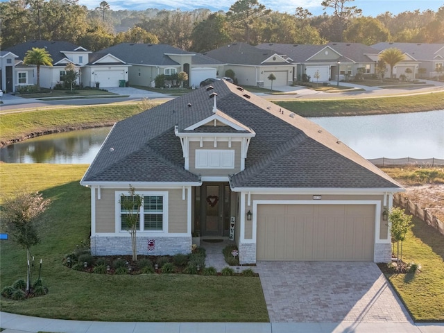 view of front of home with a water view and a front lawn