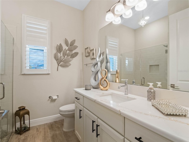 bathroom featuring hardwood / wood-style flooring, toilet, a wealth of natural light, and a shower with shower door