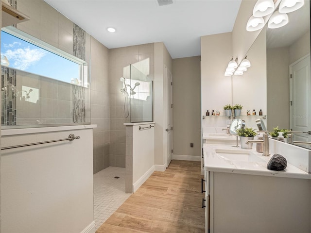 bathroom with vanity, tiled shower, and hardwood / wood-style floors