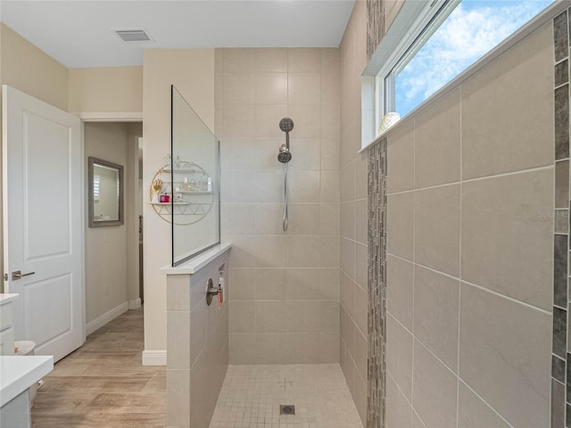 bathroom with vanity, wood-type flooring, and tiled shower