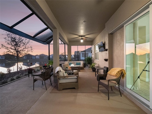 patio terrace at dusk with outdoor lounge area and ceiling fan