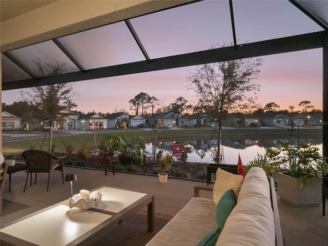 patio terrace at dusk with a water view and an outdoor living space