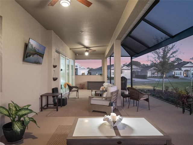 patio terrace at dusk with ceiling fan and an outdoor living space