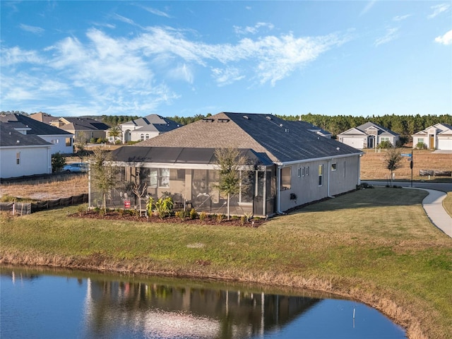 rear view of property with a water view and a yard