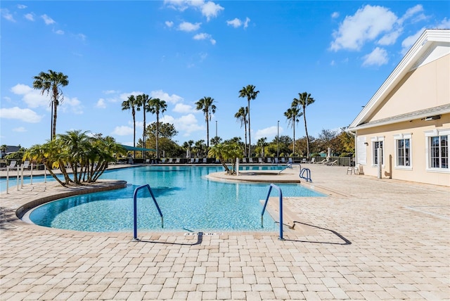 view of pool with a hot tub and a patio