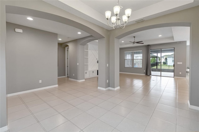 spare room featuring light tile patterned floors, baseboards, arched walkways, and a raised ceiling